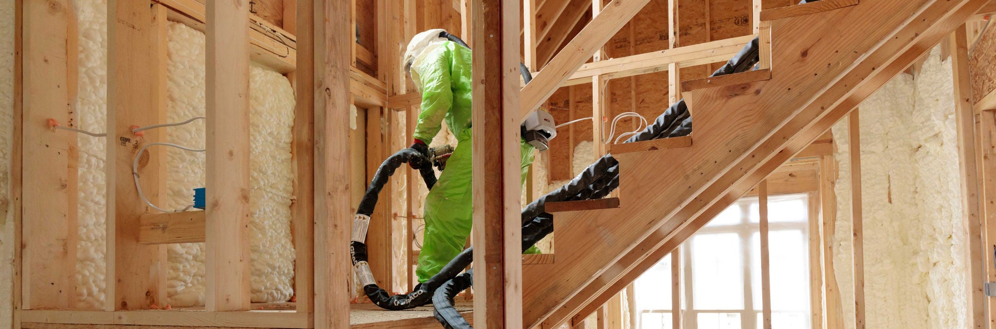 man spraying Enverge NEXSEAL insulation into wall